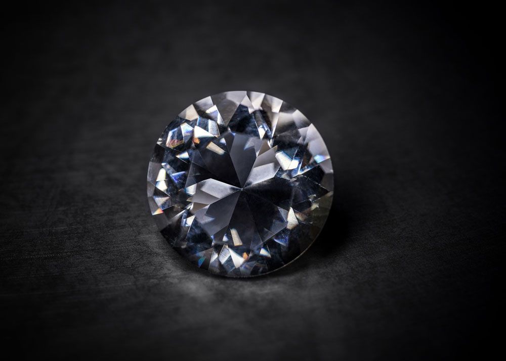 A round solitaire diamond on a black background